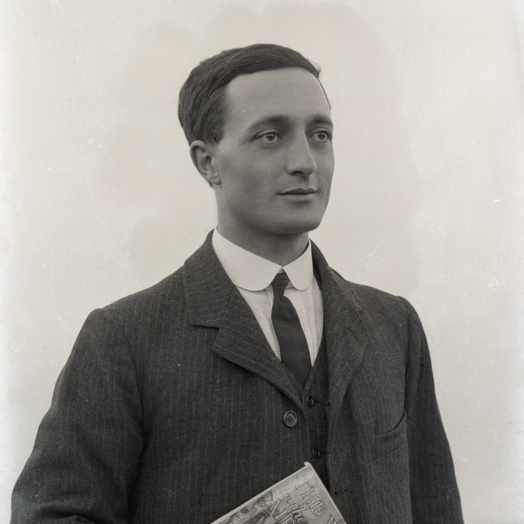 Portrair of Emile F. GUiton as a young man, holding a copy of H. G. Wells', The War in the Air